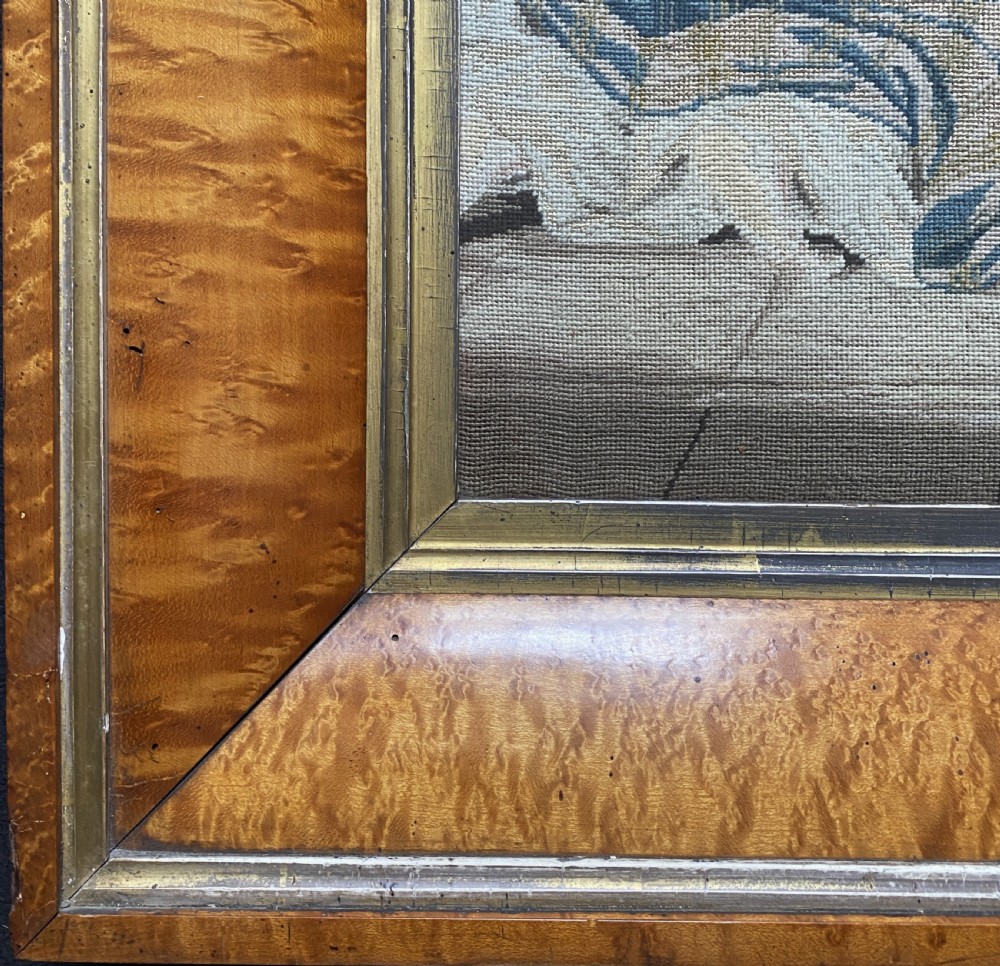 An antique Biedermeier picture frame crafted from birds eye maple veneer with an inner gilt slip enclosing a needlework tapestry. View V