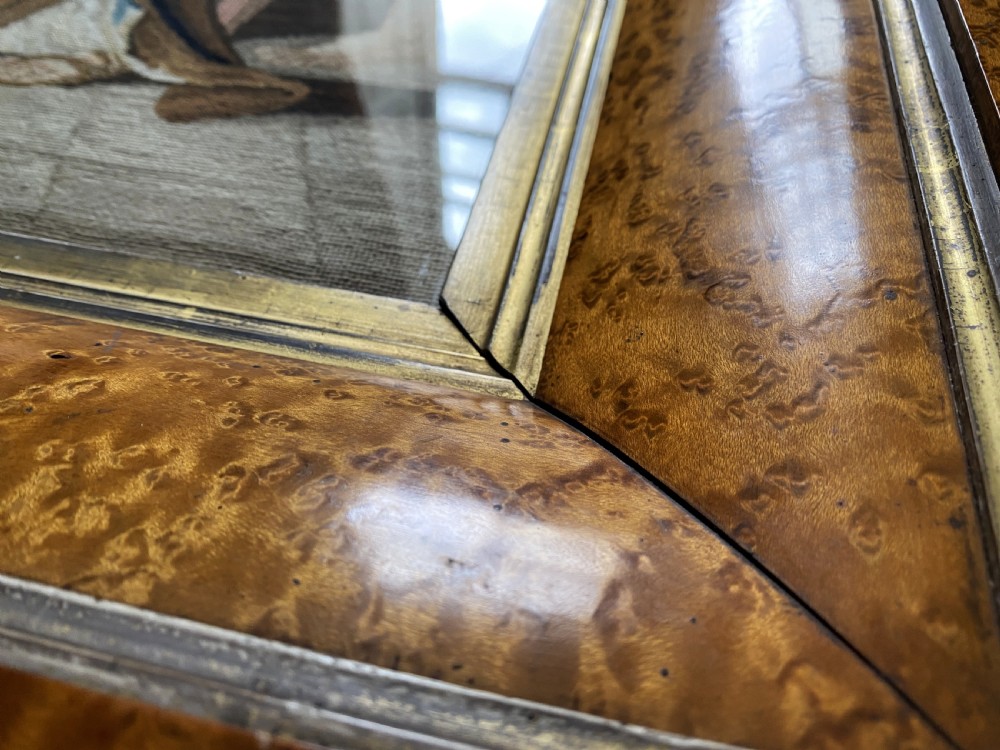 An antique Biedermeier picture frame crafted from birds eye maple veneer with an inner gilt slip enclosing a needlework tapestry. View IX