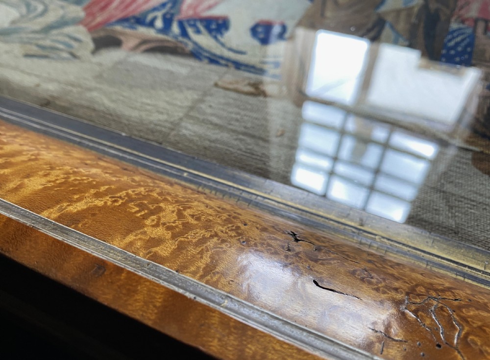 An antique Biedermeier picture frame crafted from birds eye maple veneer with an inner gilt slip enclosing a needlework tapestry. View X