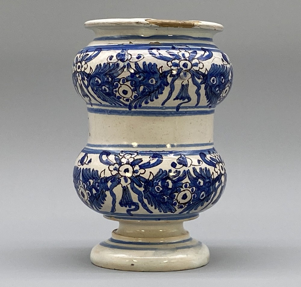 An 18th-century Italian majolica albarello pharmacy jar featuring a waisted silhouette with hand-painted blue floral patterns and central apothecary inscription. View IX