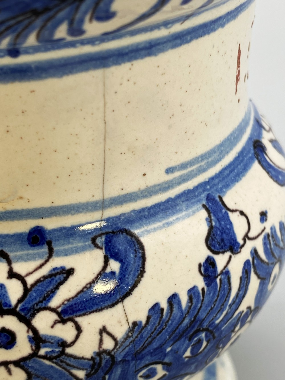 An 18th-century Italian majolica albarello pharmacy jar featuring a waisted silhouette with hand-painted blue floral patterns and central apothecary inscription. View XVIII