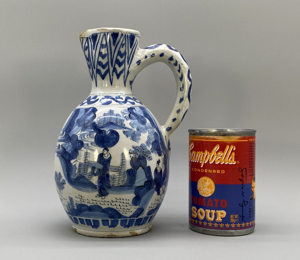 A 17th-century Dutch Delftware ceramic jug featuring hand-painted blue chinoiserie scenes on an opaque white tin glaze with a curved handle. View II