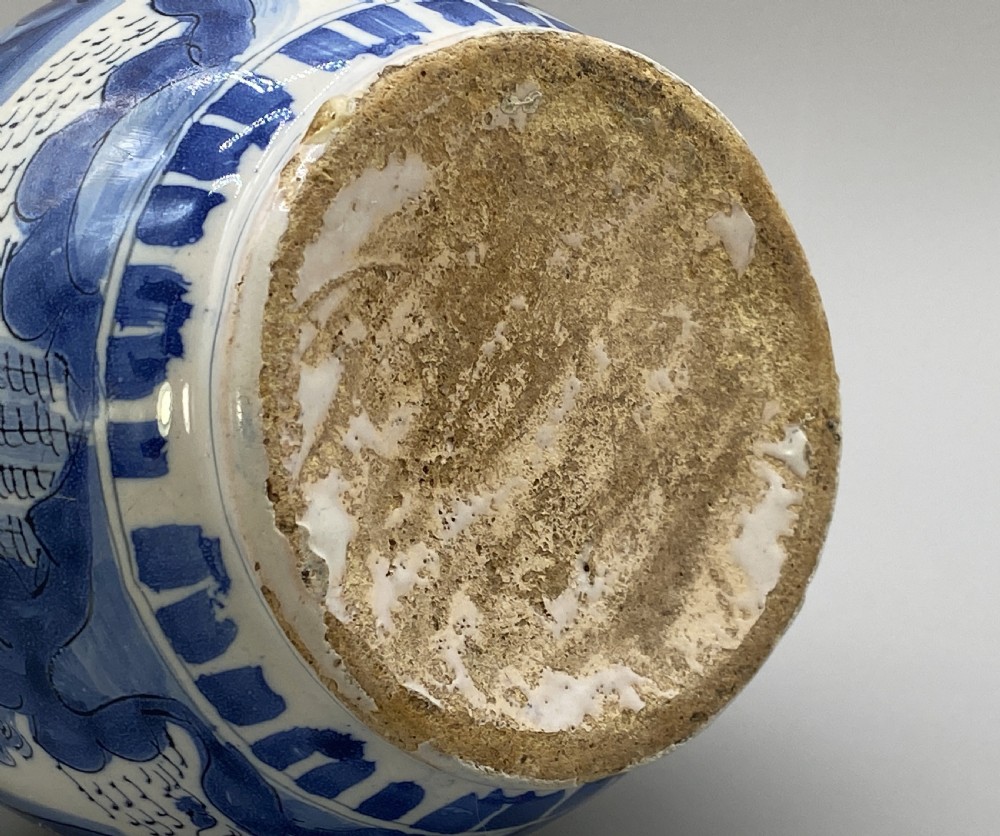 A 17th-century Dutch Delftware ceramic jug featuring hand-painted blue chinoiserie scenes on an opaque white tin glaze with a curved handle. View XX