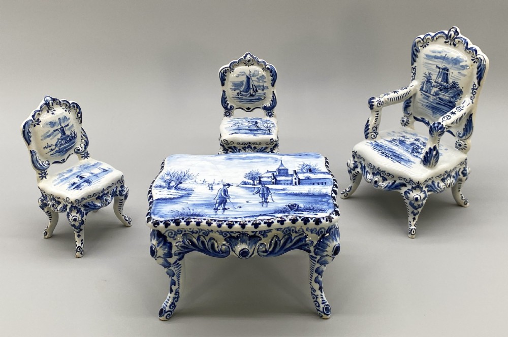 A four-piece set of miniature ceramic furniture decorated with hand-painted blue and white Dutch landscapes and windmill scenes. View III