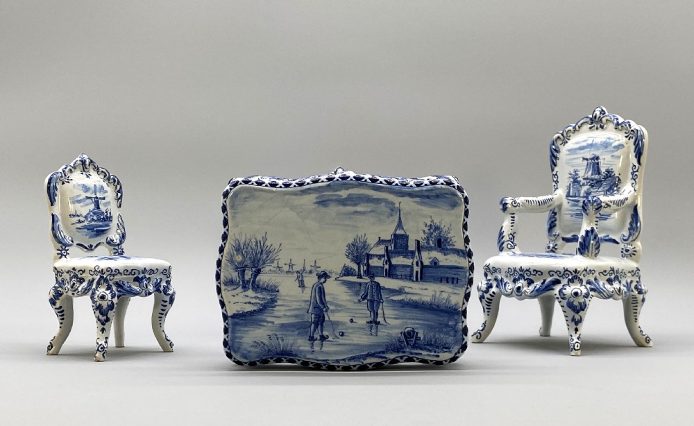 A four-piece set of miniature ceramic furniture decorated with hand-painted blue and white Dutch landscapes and windmill scenes. View V