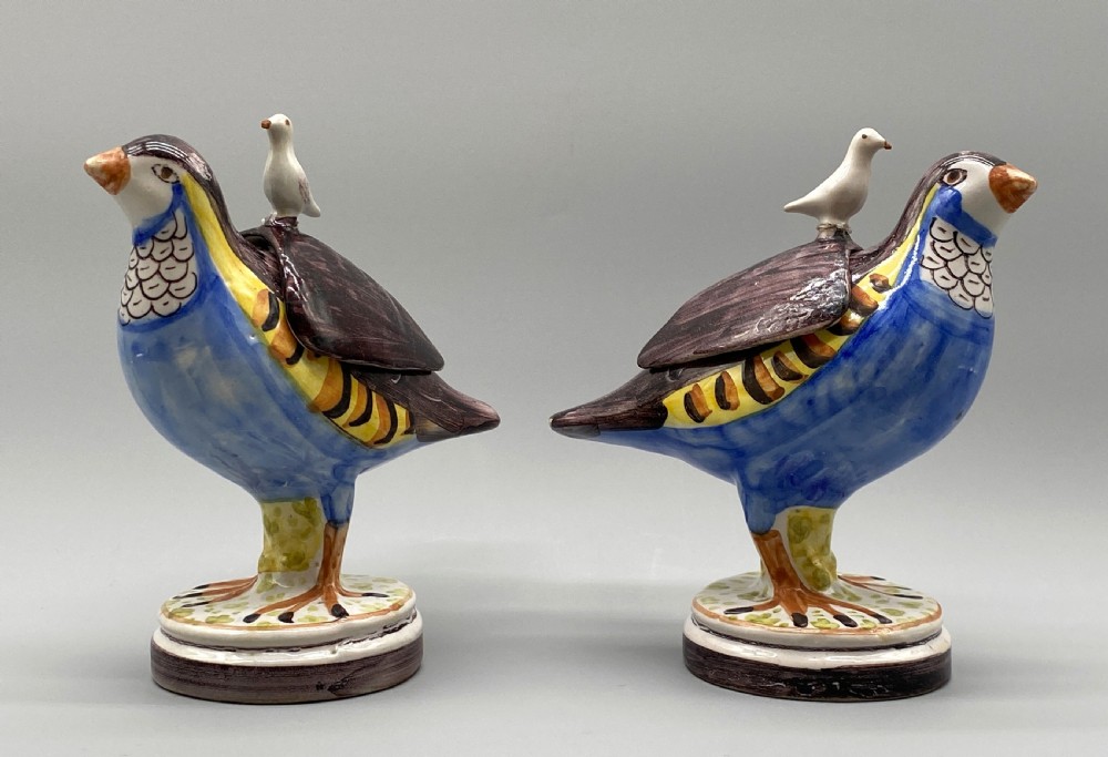 A pair of 18th-century Spanish tin-glazed faience tureens fashioned as partridges with hand-painted blue, yellow, and brown plumage and small bird finials on their removable covers. View II