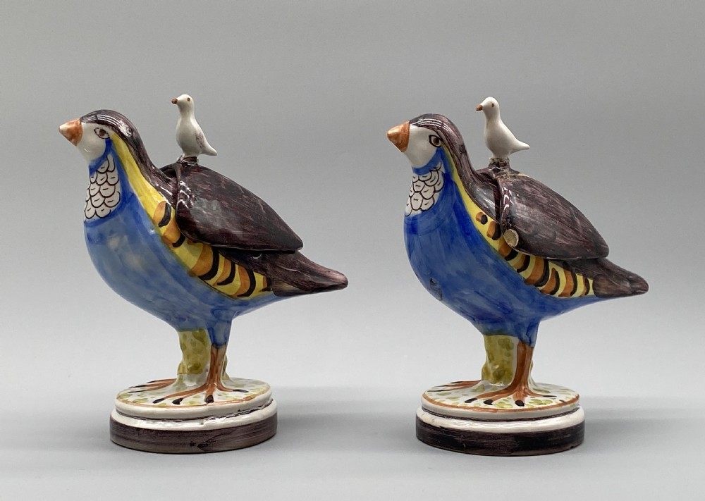 A pair of 18th-century Spanish tin-glazed faience tureens fashioned as partridges with hand-painted blue, yellow, and brown plumage and small bird finials on their removable covers. View VIII