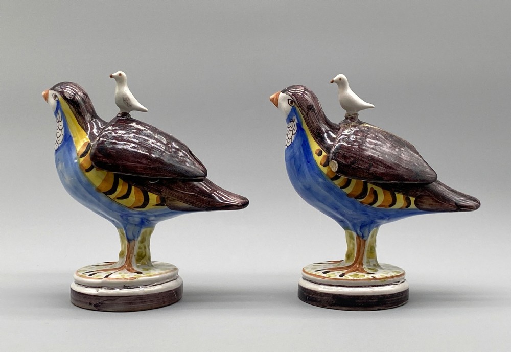 A pair of 18th-century Spanish tin-glazed faience tureens fashioned as partridges with hand-painted blue, yellow, and brown plumage and small bird finials on their removable covers. View IX