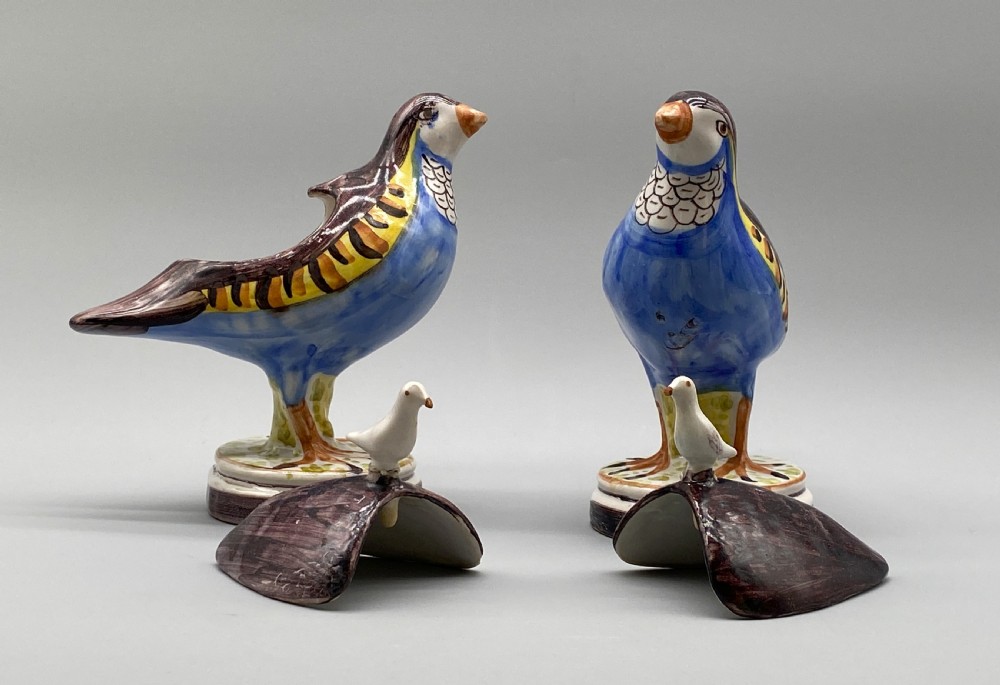 A pair of 18th-century Spanish tin-glazed faience tureens fashioned as partridges with hand-painted blue, yellow, and brown plumage and small bird finials on their removable covers. View XI