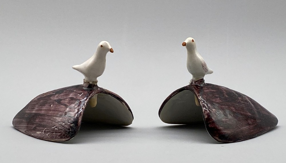 A pair of 18th-century Spanish tin-glazed faience tureens fashioned as partridges with hand-painted blue, yellow, and brown plumage and small bird finials on their removable covers. View XII
