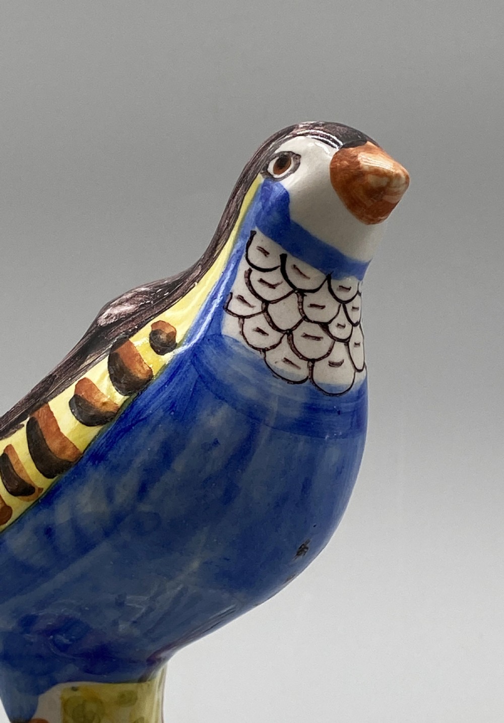 A pair of 18th-century Spanish tin-glazed faience tureens fashioned as partridges with hand-painted blue, yellow, and brown plumage and small bird finials on their removable covers. View XIII