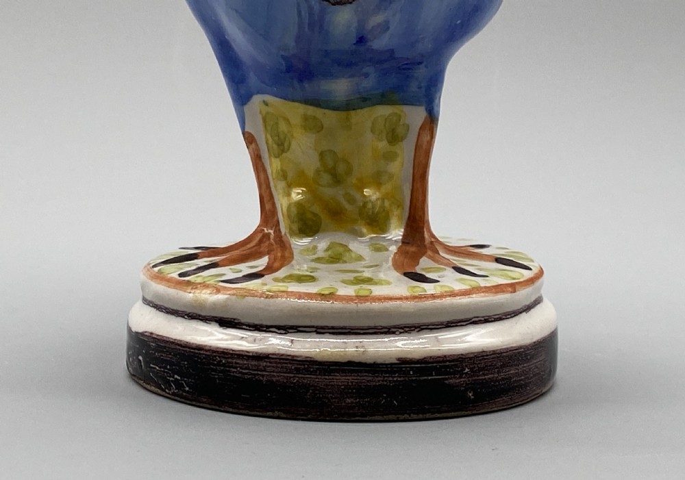 A pair of 18th-century Spanish tin-glazed faience tureens fashioned as partridges with hand-painted blue, yellow, and brown plumage and small bird finials on their removable covers. View XIV