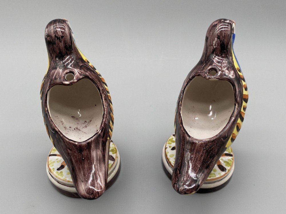 A pair of 18th-century Spanish tin-glazed faience tureens fashioned as partridges with hand-painted blue, yellow, and brown plumage and small bird finials on their removable covers. View XVI