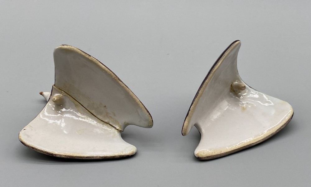 A pair of 18th-century Spanish tin-glazed faience tureens fashioned as partridges with hand-painted blue, yellow, and brown plumage and small bird finials on their removable covers. View XIX