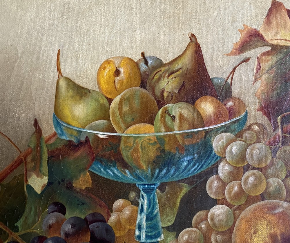 An oil painting depicting a still life composition of grapes, pears, peaches, and figs arranged on a draped cloth with a blue glass pedestal dish, enclosed in a moulded gilt frame. View VI