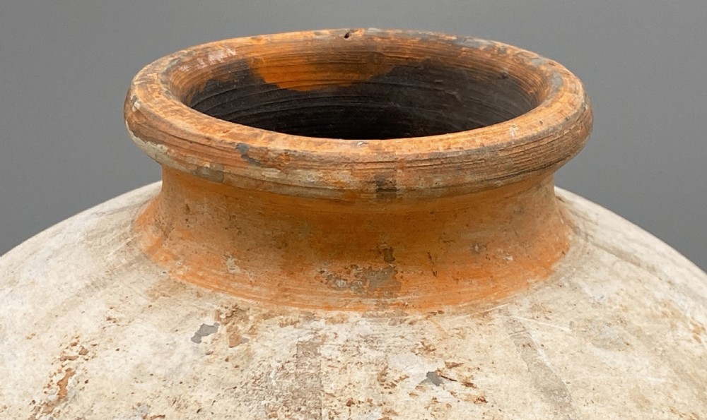 A painted terracotta vessel from the Tang Dynasty featuring a bulbous body, pointed finial lid, flared pedestal foot, and painted geometric scroll motifs in red and grey pigments. View XIII