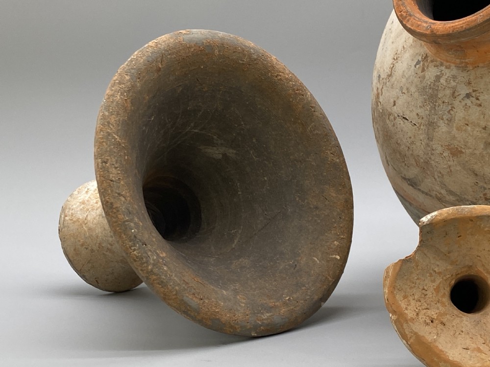 A painted terracotta vessel from the Tang Dynasty featuring a bulbous body, pointed finial lid, flared pedestal foot, and painted geometric scroll motifs in red and grey pigments. View XVII