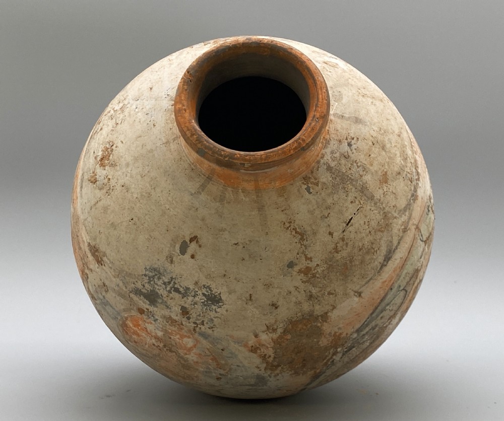 A painted terracotta vessel from the Tang Dynasty featuring a bulbous body, pointed finial lid, flared pedestal foot, and painted geometric scroll motifs in red and grey pigments. View XXII
