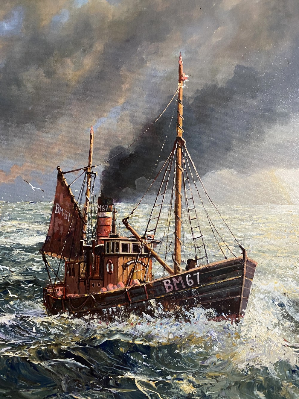 A framed oil painting depicting fishing trawlers navigating choppy sea waters near a lighthouse breakwater under a stormy sky. View X