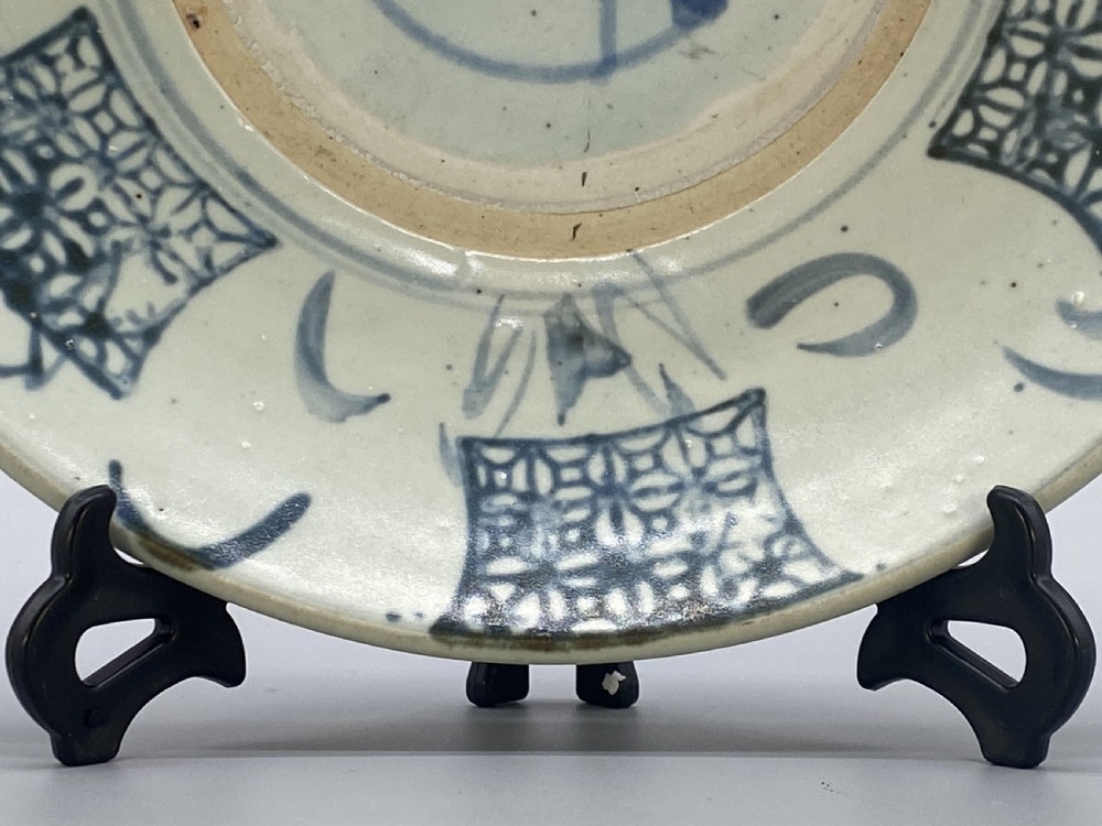 A circular 16th-century Chinese Swatow blue and white porcelain charger dish decorated with underglaze cobalt painted panels and central calligraphic motif. View IX