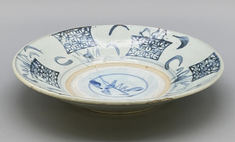 A circular 16th-century Chinese Swatow blue and white porcelain charger dish decorated with underglaze cobalt painted panels and central calligraphic motif. View XIII
