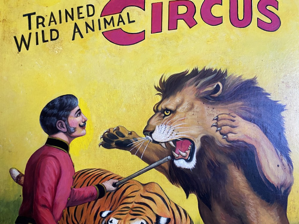 A framed mid-twentieth-century oil painting depicting a lion tamer confronting a roaring lion and a tiger against a yellow background with bold red circus lettering. View IX
