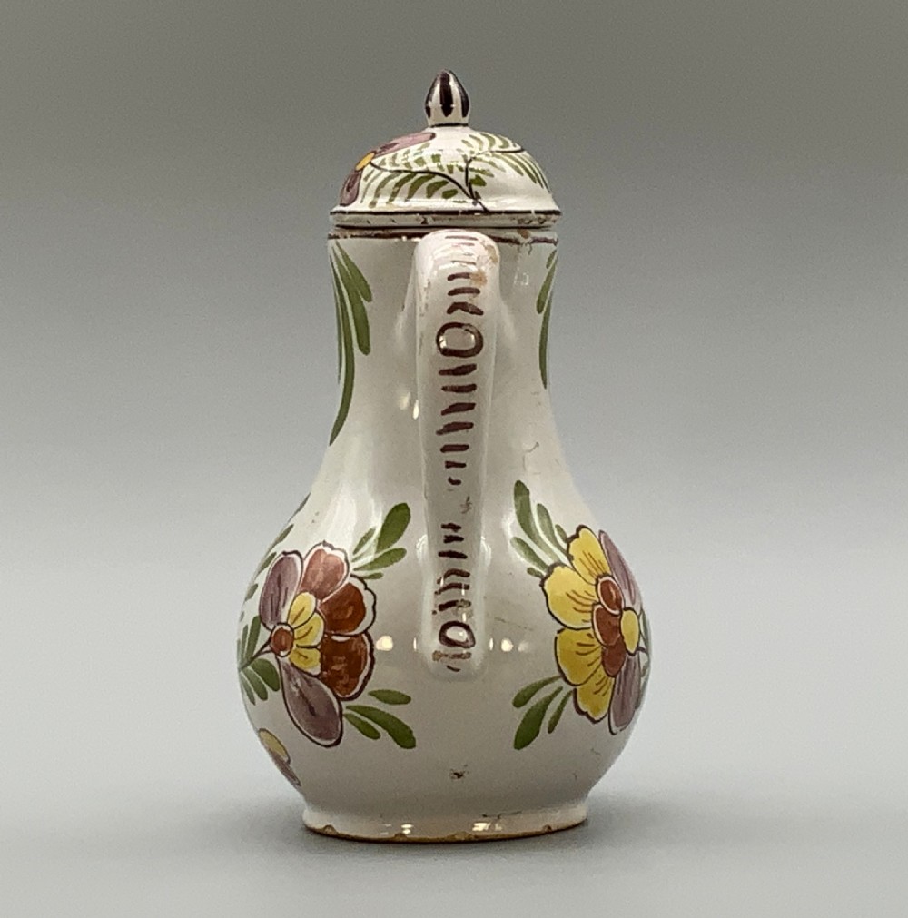 An 18th-century Dutch Delft tin-glazed ceramic coffee pot decorated with polychrome floral motifs and a central blue maritime landscape medallion. View VI