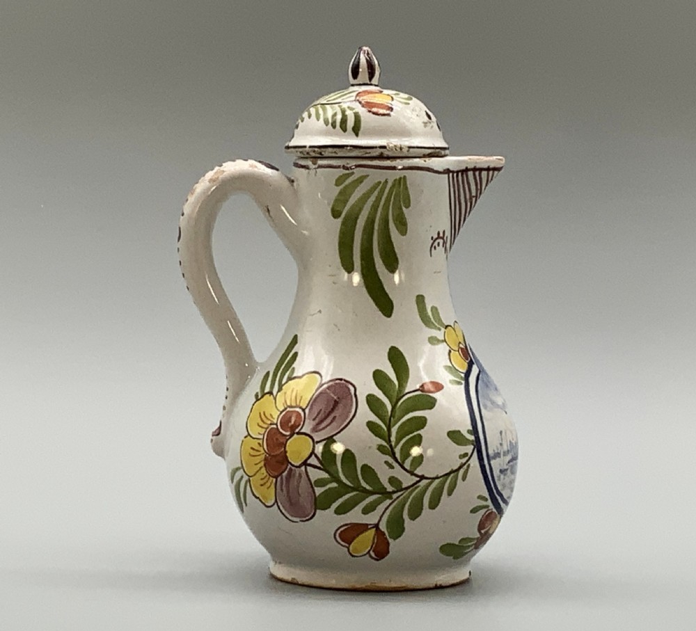 An 18th-century Dutch Delft tin-glazed ceramic coffee pot decorated with polychrome floral motifs and a central blue maritime landscape medallion. View VII