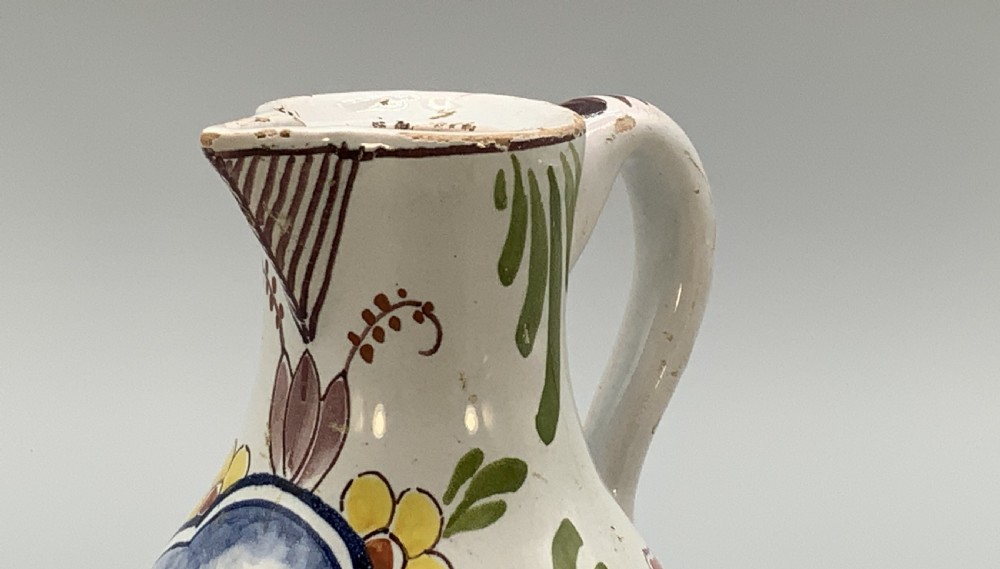 An 18th-century Dutch Delft tin-glazed ceramic coffee pot decorated with polychrome floral motifs and a central blue maritime landscape medallion. View XI