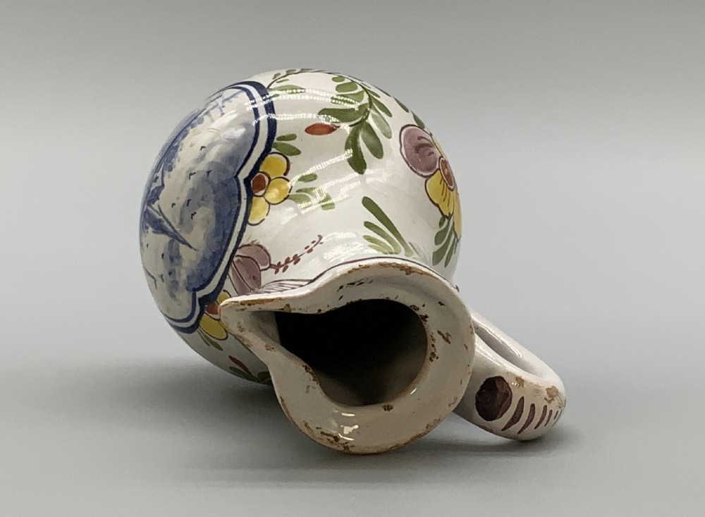 An 18th-century Dutch Delft tin-glazed ceramic coffee pot decorated with polychrome floral motifs and a central blue maritime landscape medallion. View XIV