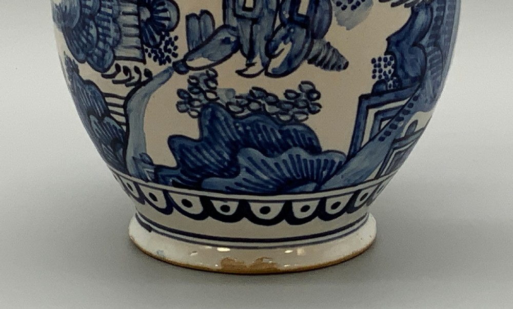 An antique Dutch Delftware ceramic jug decorated with cobalt blue hand-painted Chinoiserie figures and botanical motifs against a white tin glaze. View IX