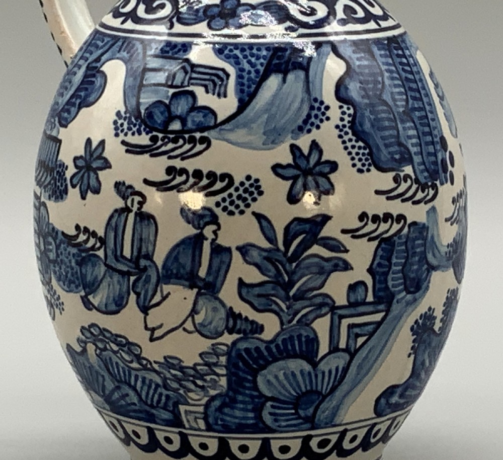 An antique Dutch Delftware ceramic jug decorated with cobalt blue hand-painted Chinoiserie figures and botanical motifs against a white tin glaze. View XI