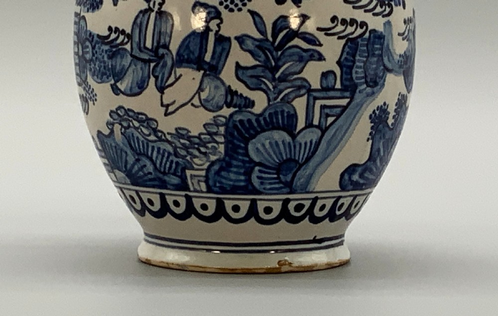 An antique Dutch Delftware ceramic jug decorated with cobalt blue hand-painted Chinoiserie figures and botanical motifs against a white tin glaze. View XII