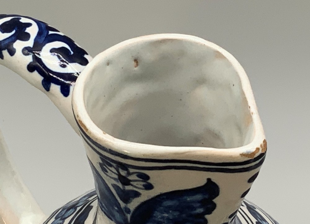 An antique Dutch Delftware ceramic jug decorated with cobalt blue hand-painted Chinoiserie figures and botanical motifs against a white tin glaze. View XIII