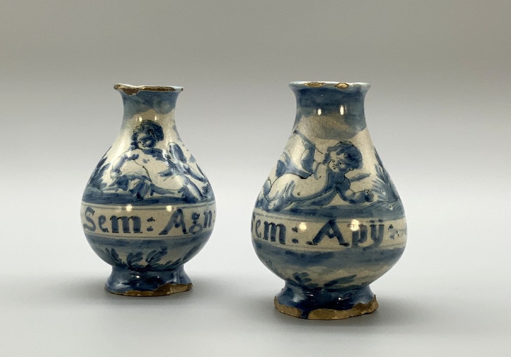 Pair of 17th-century Italian Savona majolica apothecary bottles with cobalt blue hand-painted putti and Latin inscriptions over a tin-glazed ground. View XVII