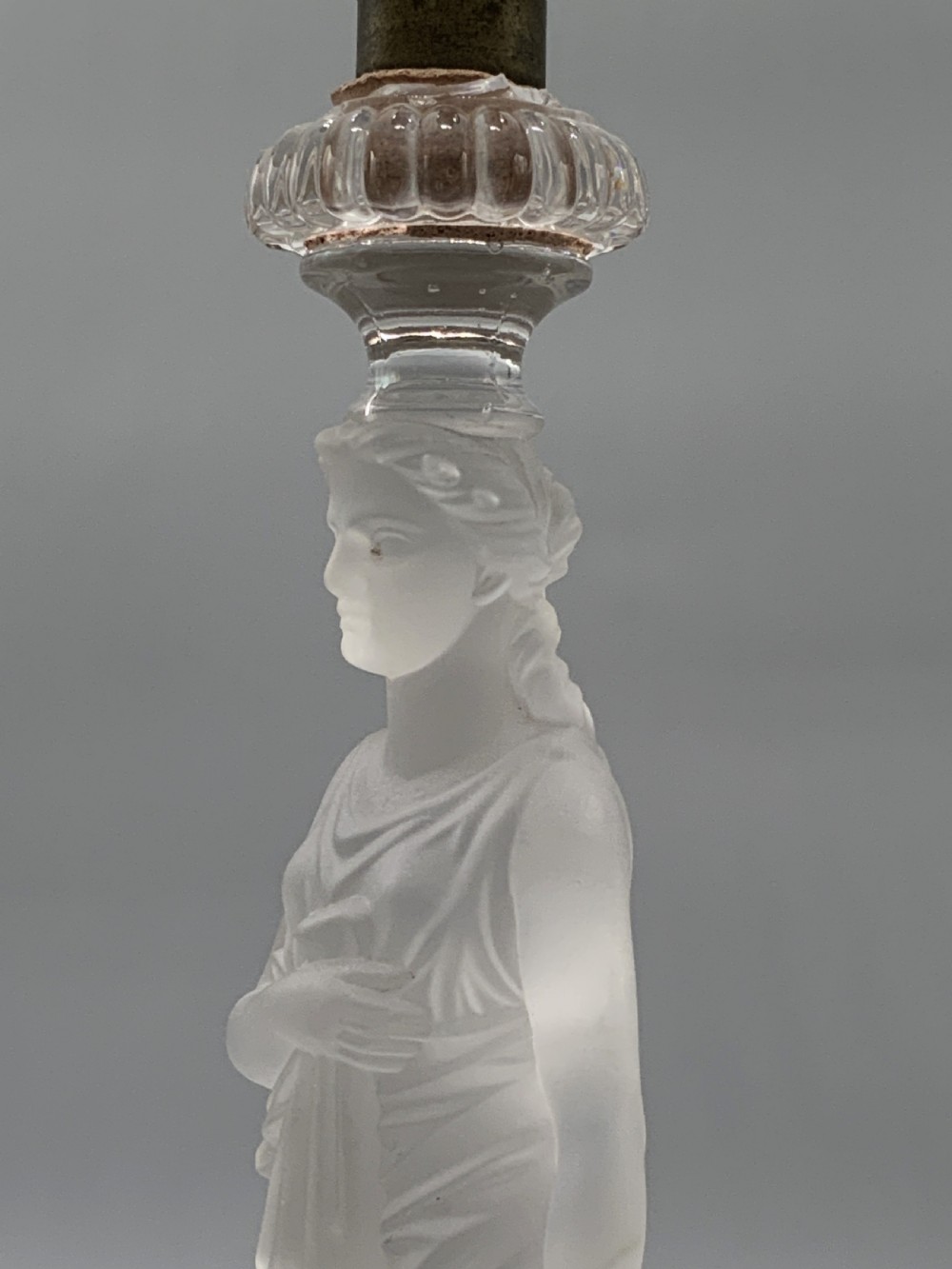 An early 20th-century French table lamp featuring a frosted glass classical figurine mounted on a square stone base, topped with a pleated blue floral lampshade. View VIII