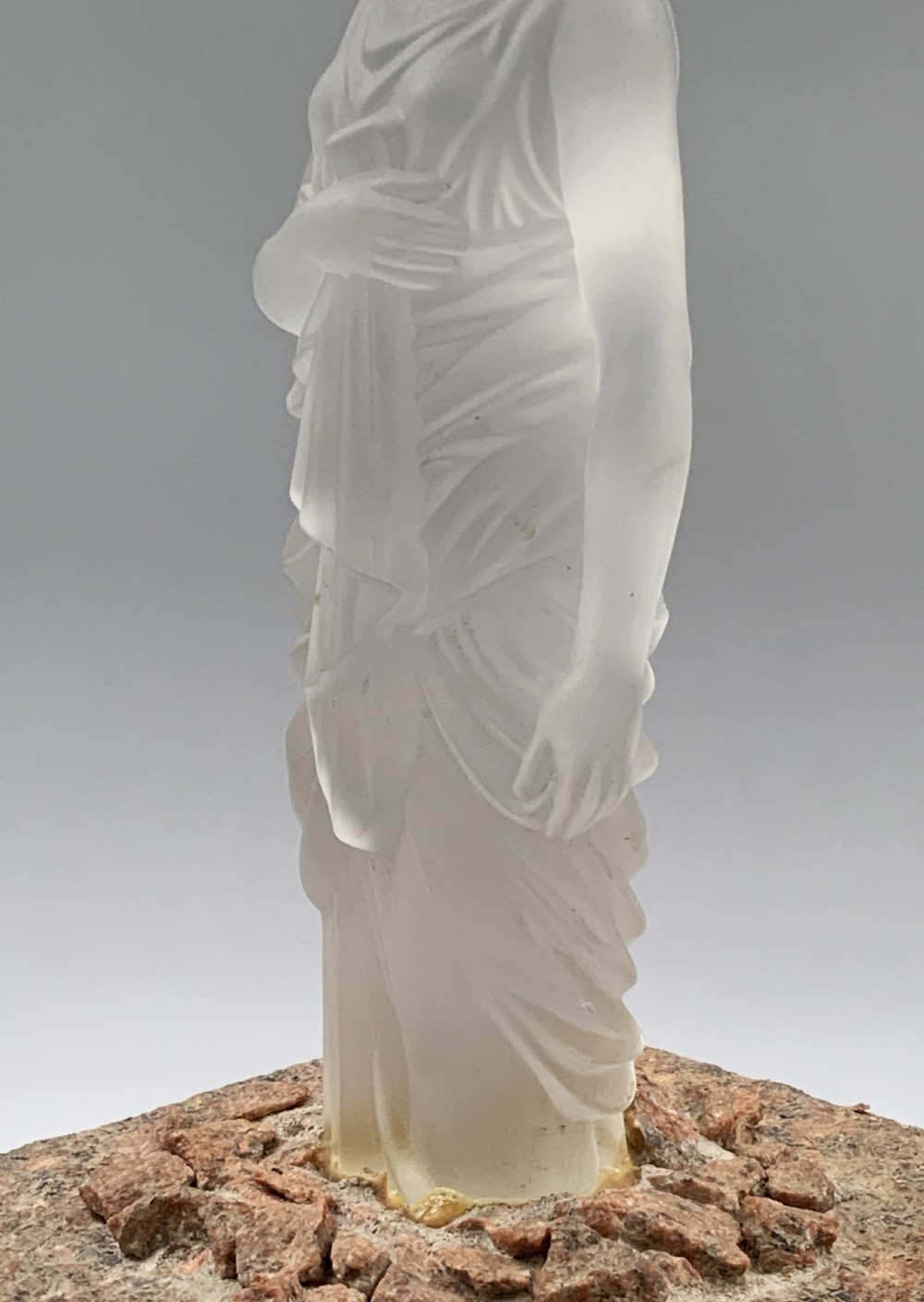 An early 20th-century French table lamp featuring a frosted glass classical figurine mounted on a square stone base, topped with a pleated blue floral lampshade. View IX