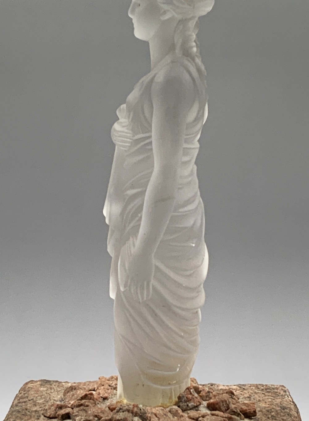 An early 20th-century French table lamp featuring a frosted glass classical figurine mounted on a square stone base, topped with a pleated blue floral lampshade. View XI