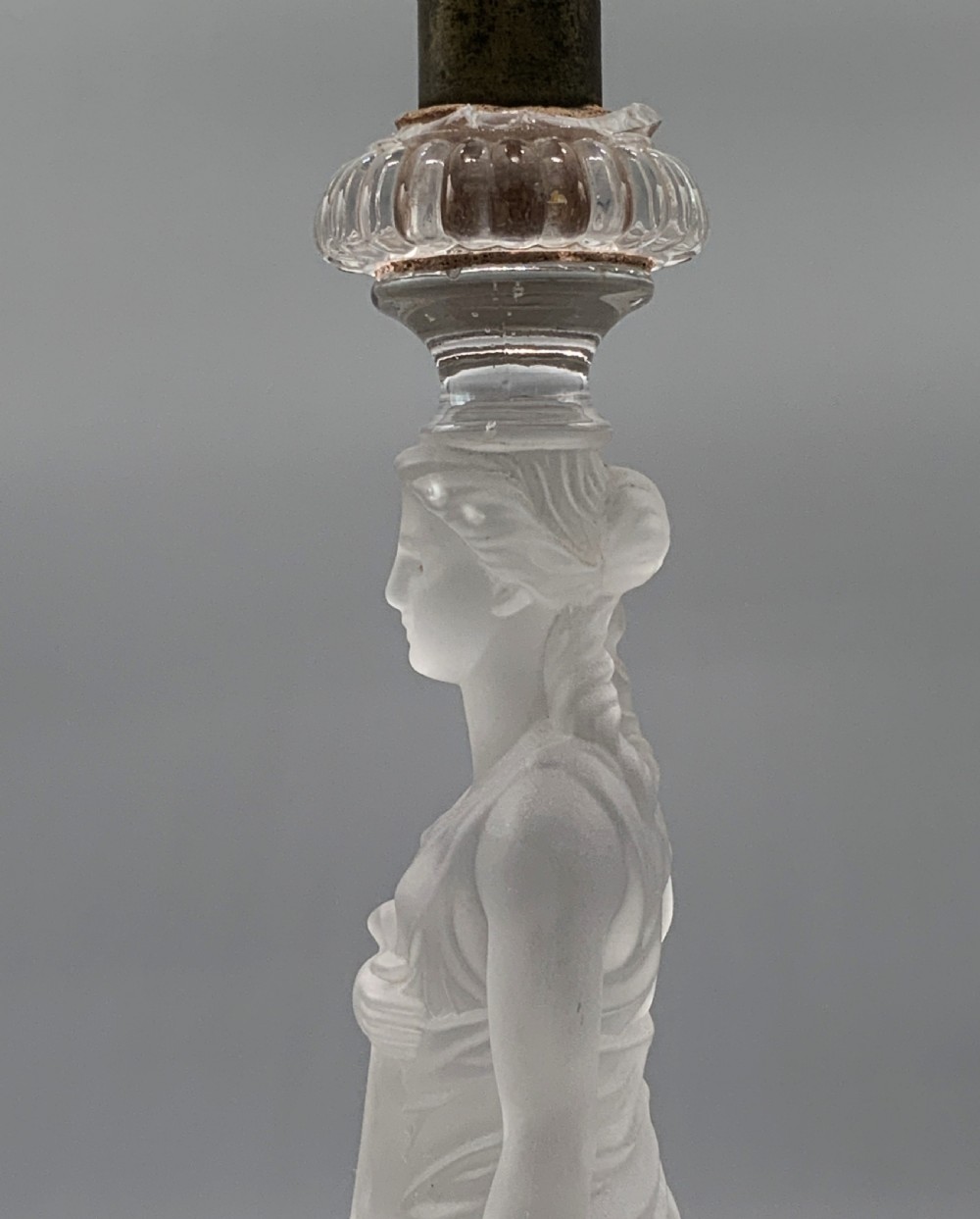 An early 20th-century French table lamp featuring a frosted glass classical figurine mounted on a square stone base, topped with a pleated blue floral lampshade. View XII