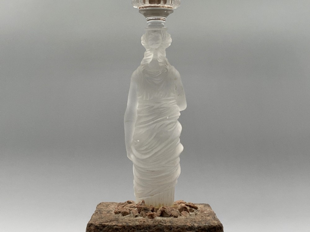 An early 20th-century French table lamp featuring a frosted glass classical figurine mounted on a square stone base, topped with a pleated blue floral lampshade. View XIV
