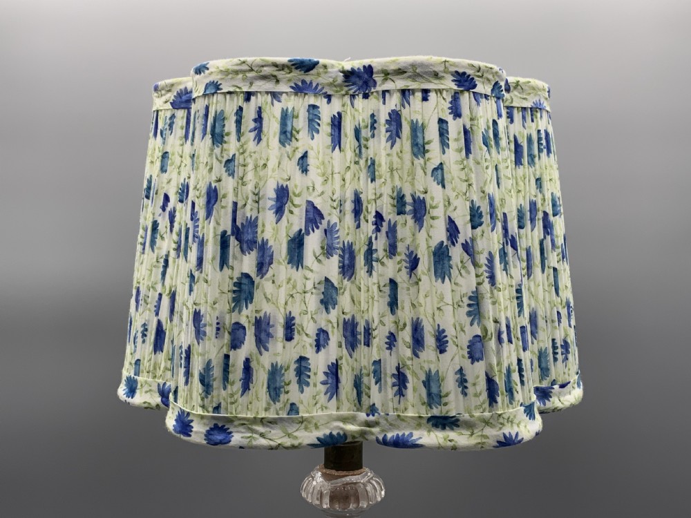 An early 20th-century French table lamp featuring a frosted glass classical figurine mounted on a square stone base, topped with a pleated blue floral lampshade. View XIX