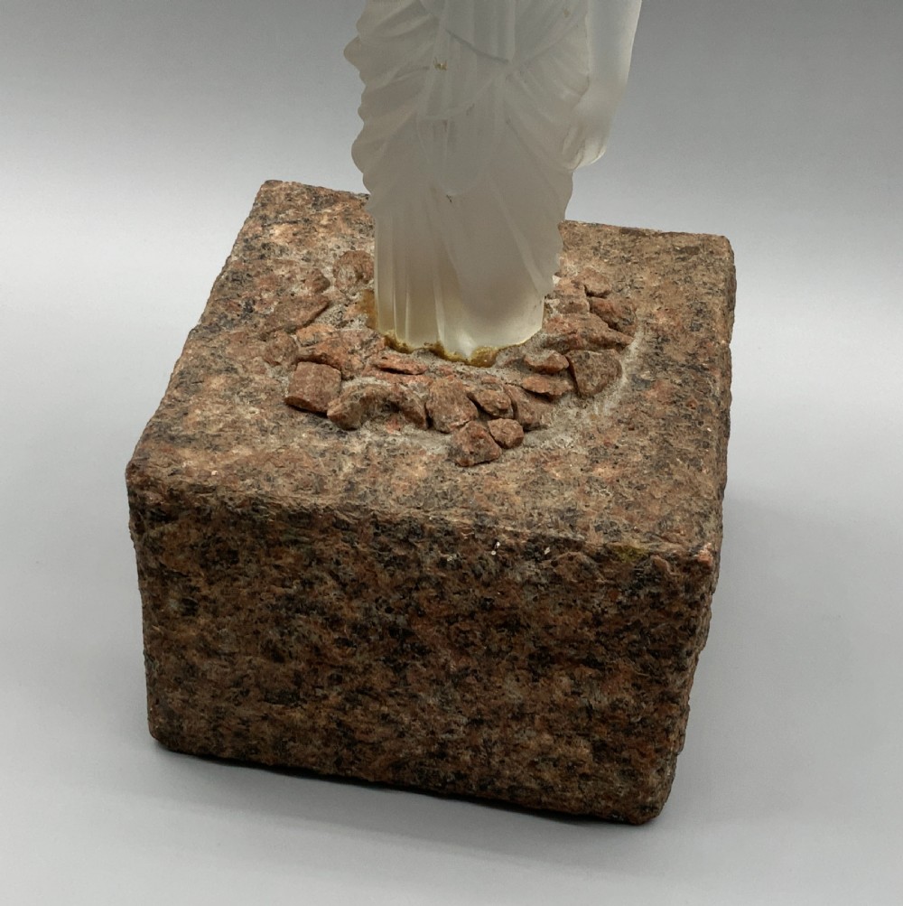 An early 20th-century French table lamp featuring a frosted glass classical figurine mounted on a square stone base, topped with a pleated blue floral lampshade. View XX