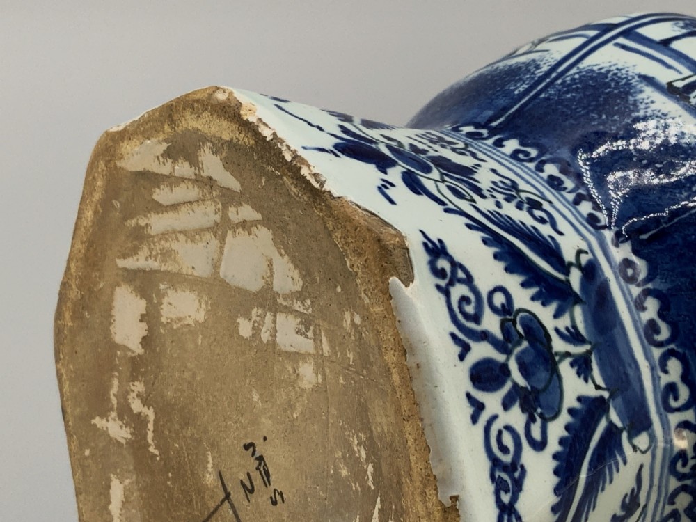 A tall, octagonal blue and white tin-glazed earthenware vase featuring a garlic bulb neck and hand-painted Chinoiserie scenes within arched panels. View XVI