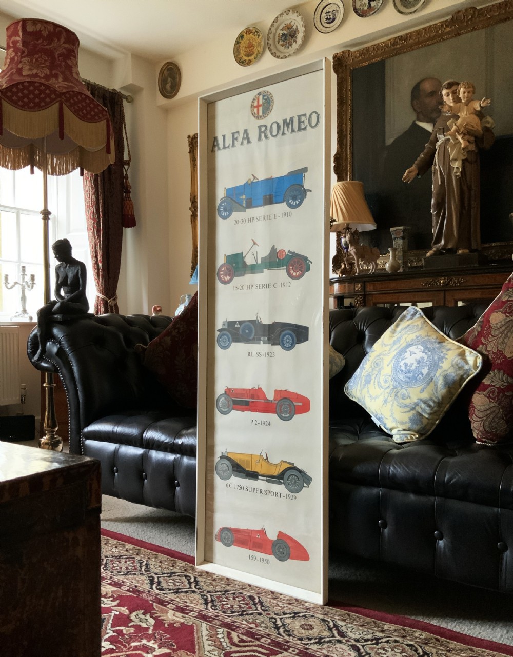 A long vertical glazed poster displaying six illustrated historical Alfa Romeo motor cars arranged chronologically from 1910 to 1950 on a cream paper background inside a white frame. View II