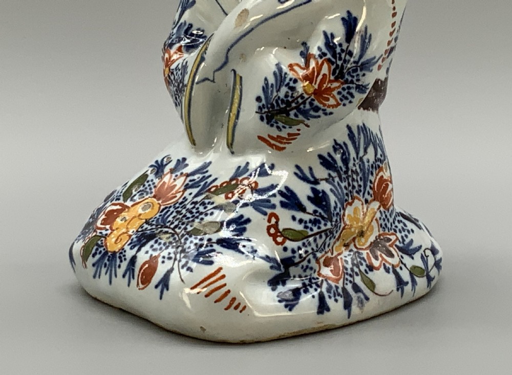 An 18th-century Dutch Delftware ceramic candlestick formed as a kneeling bishop in patterned robes and a mitre decorated with polychrome glazes. View XI