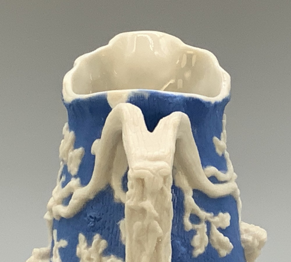 A Victorian blue and white Parian ware jug featuring a textured cobalt blue ground with raised white relief figures climbing a tree and a moulded branch handle. View XII