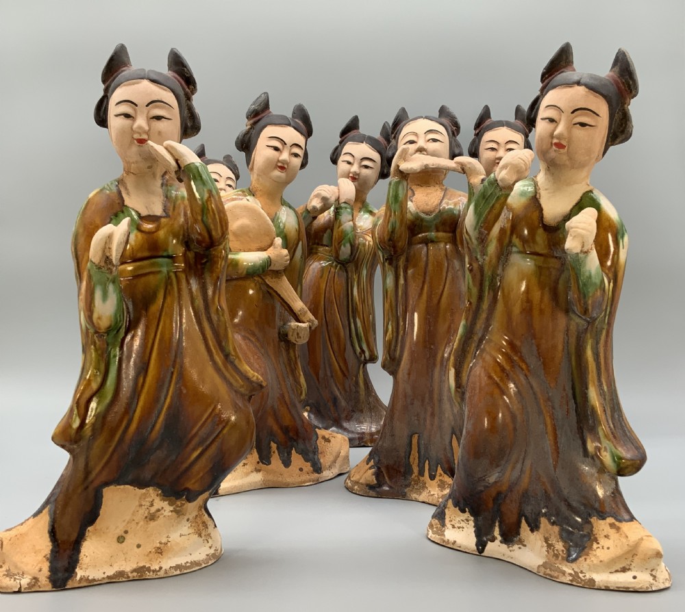 A set of seven Tang dynasty style lead-glazed earthenware figurines depicting standing female court musicians holding traditional instruments.