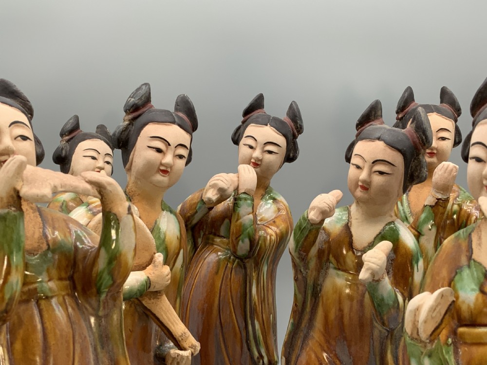 A set of seven Tang dynasty style lead-glazed earthenware figurines depicting standing female court musicians holding traditional instruments. View VIII