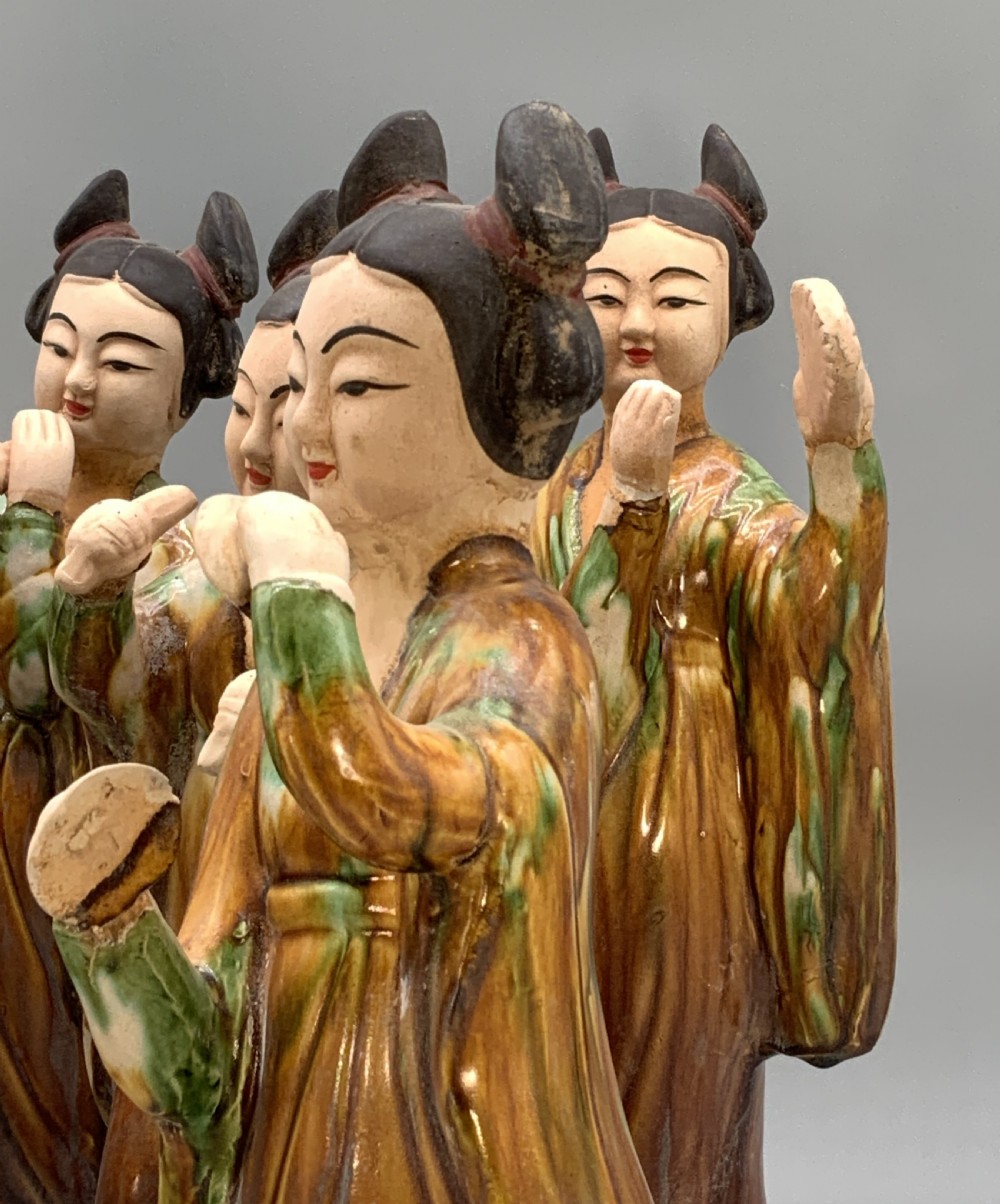 A set of seven Tang dynasty style lead-glazed earthenware figurines depicting standing female court musicians holding traditional instruments. View IX