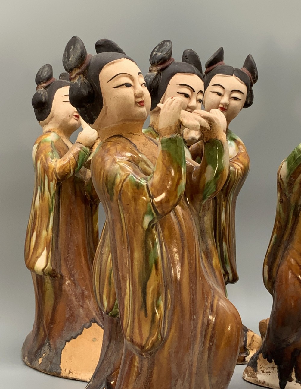 A set of seven Tang dynasty style lead-glazed earthenware figurines depicting standing female court musicians holding traditional instruments. View X